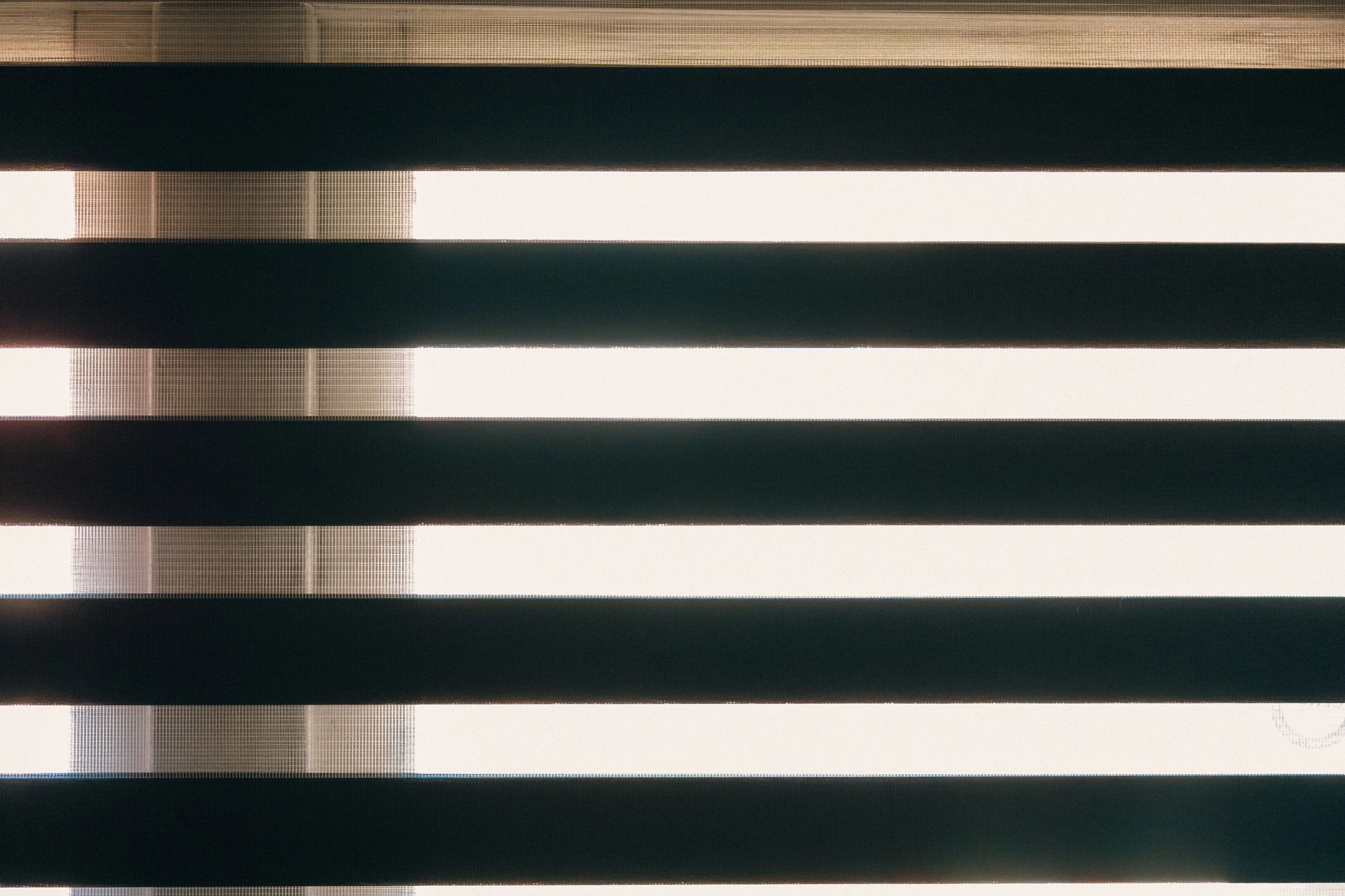 Blinds creating patterned light and shadow